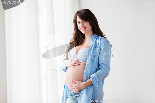 Image of happy pregnant woman with big tummy at home