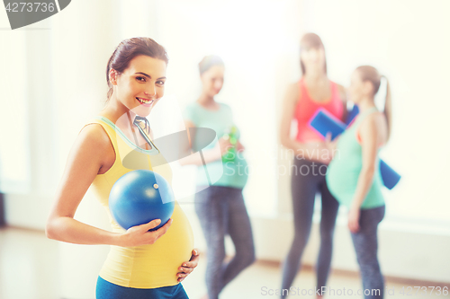 Image of happy pregnant woman with ball in gym