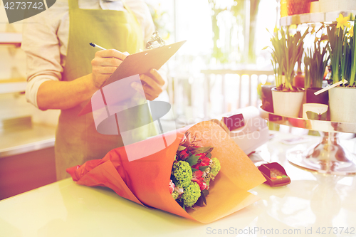 Image of close up of man with clipboard at flower shop