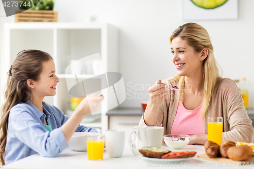 Image of happy family having breakfast at home kitchen