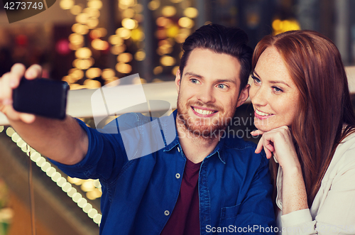 Image of couple taking selfie by smartphone at restaurant