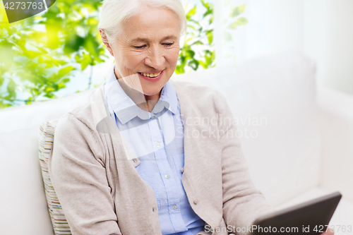 Image of happy senior woman with tablet pc at home