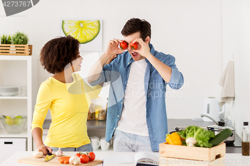 Image of happy couple cooking food and having fun at home