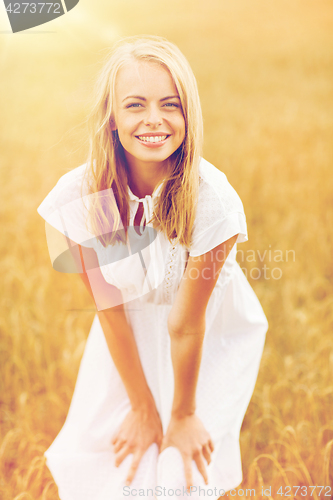 Image of smiling young woman in white dress on cereal field