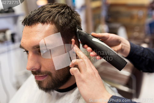 Image of man and barber hands with trimmer cutting hair