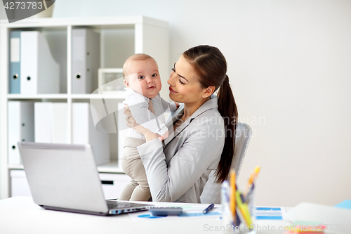 Image of happy businesswoman with baby and laptop at office