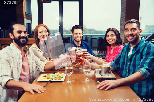 Image of friends dining and drinking beer at restaurant