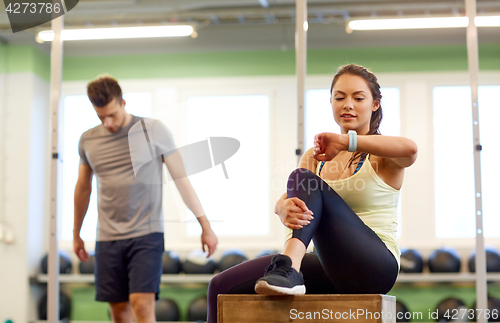 Image of man and woman with heart rate tracker in gym