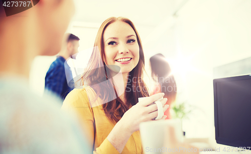 Image of happy creative team drinking coffee at office