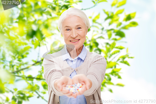 Image of happy senior woman with medicine at home