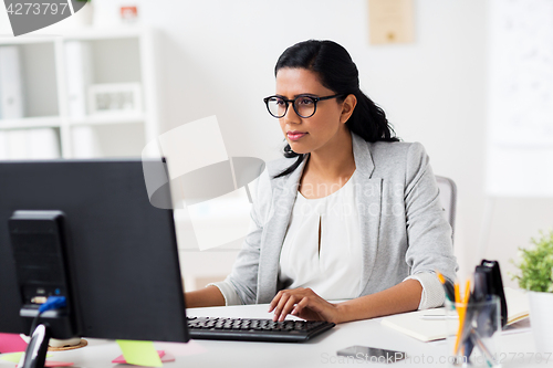 Image of businesswoman with laptop working at office