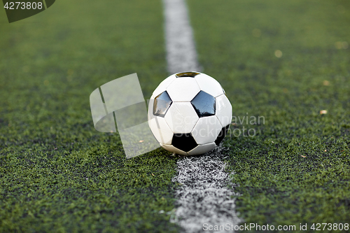 Image of soccer ball on football field marking line