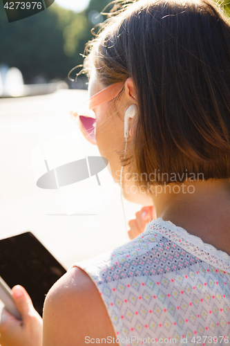 Image of Anonymous woman with tablet in sunlight