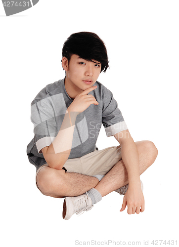 Image of Young Asian man sitting on floor.