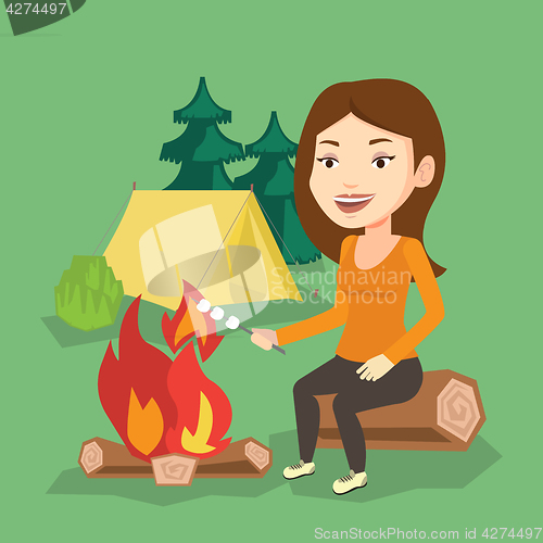 Image of Woman roasting marshmallow over campfire.