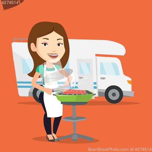 Image of Woman having barbecue in front of camper van.