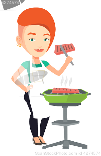 Image of Woman cooking steak on barbecue grill.