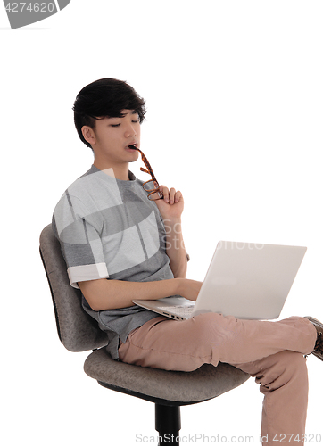 Image of Young man working at laptop.