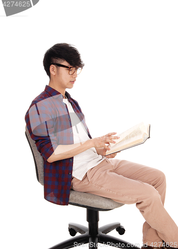 Image of Asian teenager reading book.