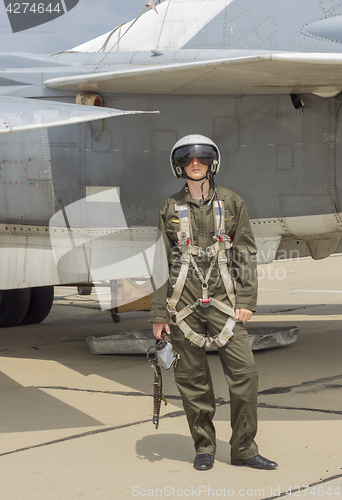 Image of Military pilot in helmet stands near jet plane