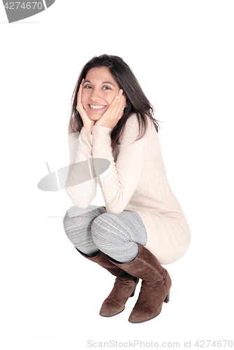 Image of Happy woman crouching on floor.