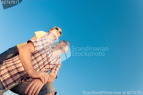 Image of Dad and daughter in sunglasses playing near a house at the day t