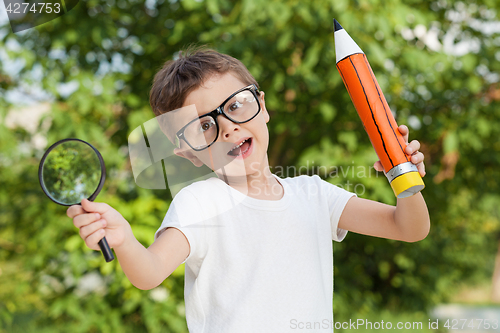 Image of Smiling young child in a uniform standing against a tree in the 