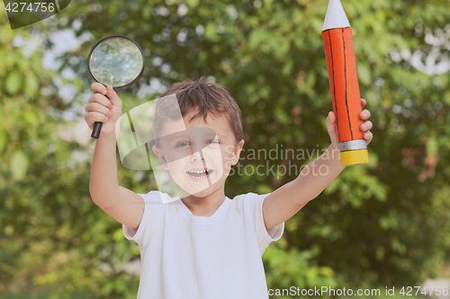 Image of Smiling young child in a uniform standing against a tree in the 