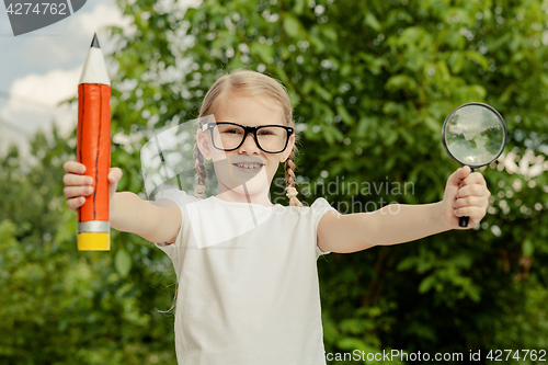 Image of Smiling young child in a uniform standing against a tree in the 