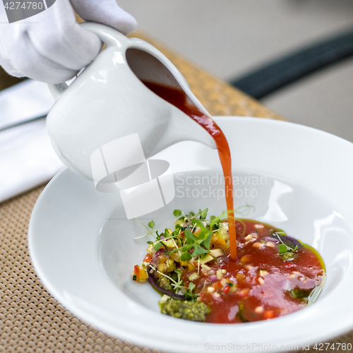 Image of Waiter serving gazpacho, tomato soup 