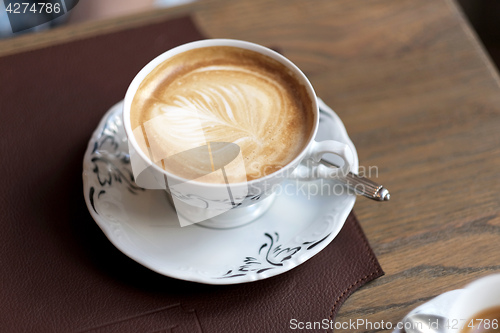 Image of view of cappuccino served on wooden table