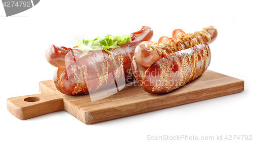 Image of two hotdogs on wooden cutting board