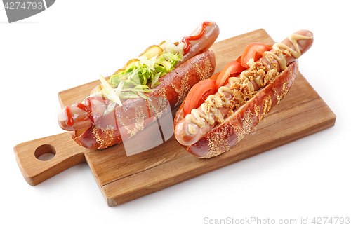 Image of two hotdogs on wooden cutting board