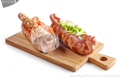 Image of two hotdogs on wooden cutting board