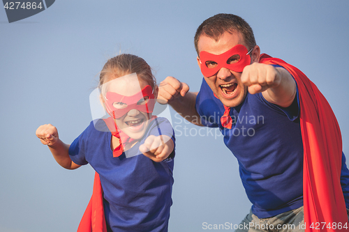 Image of Father and daughter playing superhero outdoors at the day time.