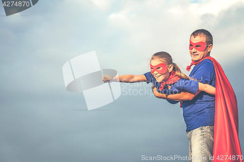 Image of Father and daughter playing superhero outdoors at the day time.