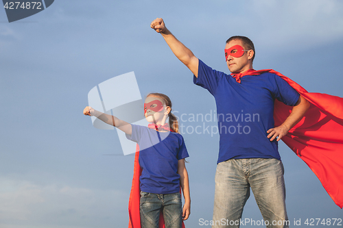 Image of Father and daughter playing superhero outdoors at the day time.