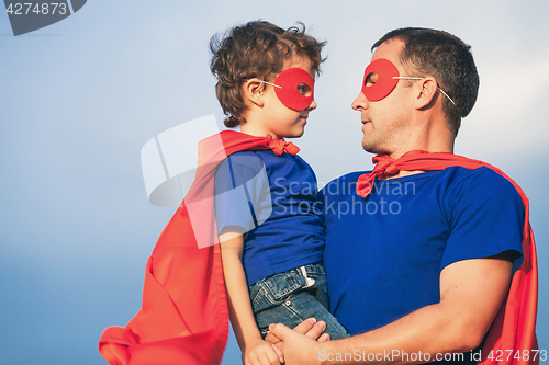 Image of Father and son playing superhero outdoors at the day time.