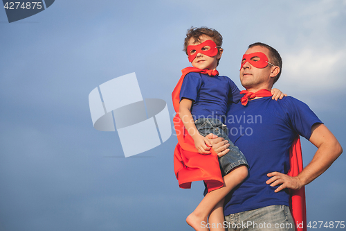 Image of Father and son playing superhero outdoors at the day time.