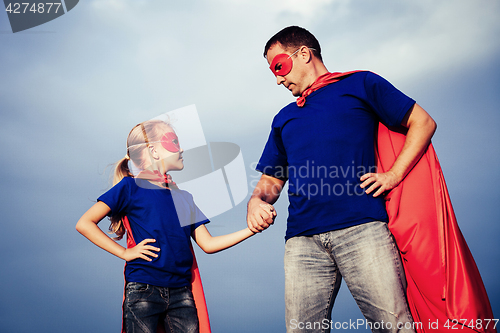 Image of Father and daughter playing superhero outdoors at the day time.