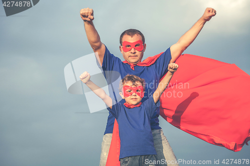 Image of Father and son playing superhero outdoors at the day time.