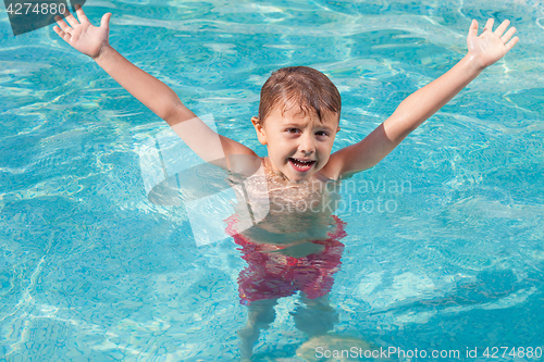 Image of one happy child playing on the swimming pool at the day time.