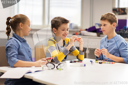 Image of happy children building robots at robotics school