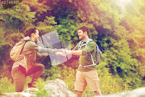 Image of smiling couple with backpacks hiking