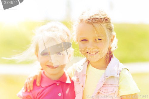 Image of happy little girls hugging outdoors at summer