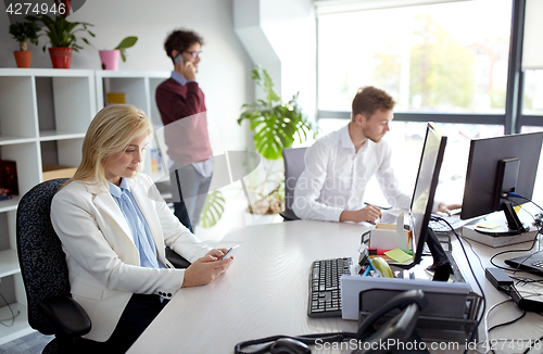 Image of business team with smartphones at office