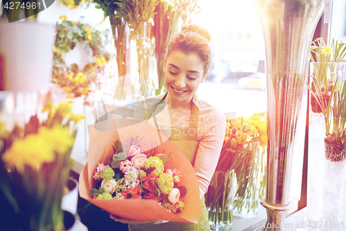 Image of smiling florist woman with bunch at flower shop