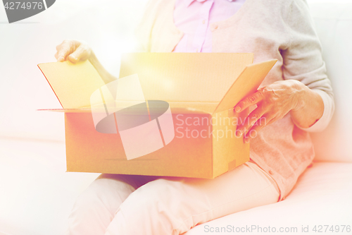 Image of close up of senior woman with parcel box at home