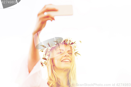 Image of happy young woman taking smartphone selfie