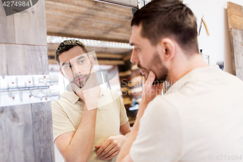 Image of man looking at himself at barbershop mirror